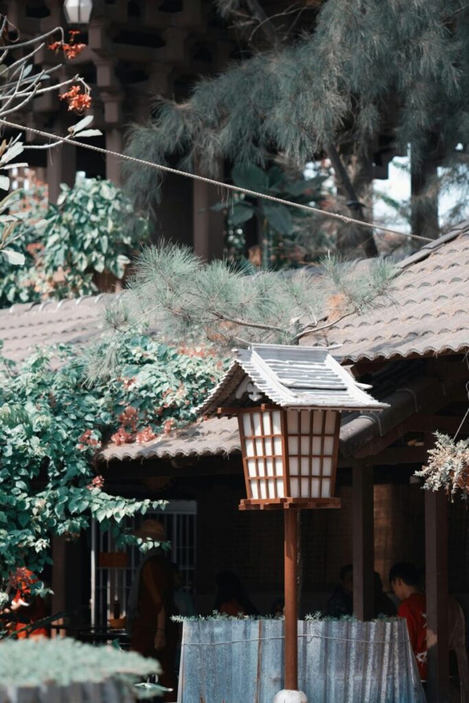 A peaceful scene of a Japanese garden featuring a traditional lantern surrounded by foliage.