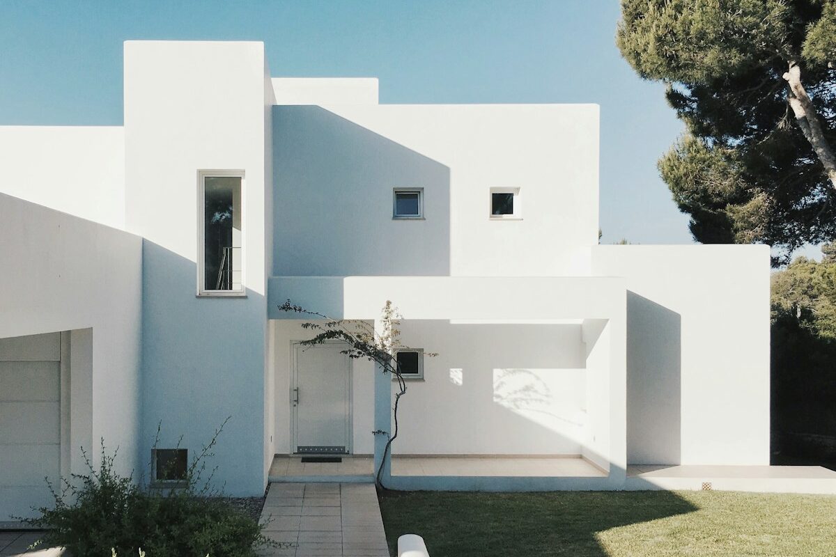 white concrete house near green tree during daytime